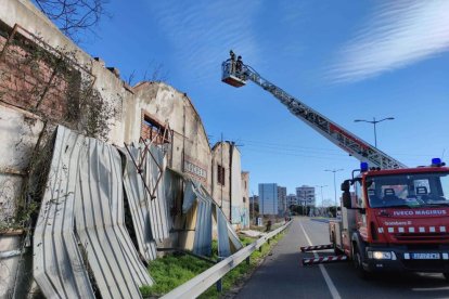 Los bomberos trabajando para retirar las planchas metálicas.