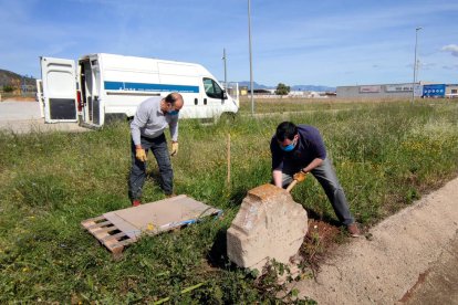 Dos operaris retirant la creu de l'antiga diligència de Barcelona a València del segle XIX que s'ha recuperat a Amposta.