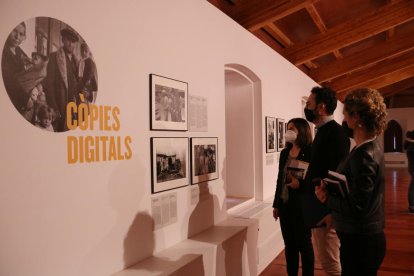 Pere Segura; la regidora de Cultura, Manuela Moya; i de la directora de projectes externs de la Fundació Vila Casas, Natàlia Chocarro, mirant les fotografies inèdites.