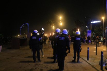 Agents de la Guàrdia Urbana de Barcelona desallotjant el 'botellón' de la platja de Sant Miquel, a la Barceloneta.