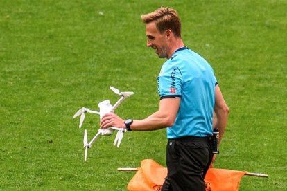 El col·legiat Valentín Pizarro retira un dron que ha caigut al terreny de joc durant el partit de LaLiga entre l'Athletic i l'Eibar celebrat aquest dissabte en San Mamés.