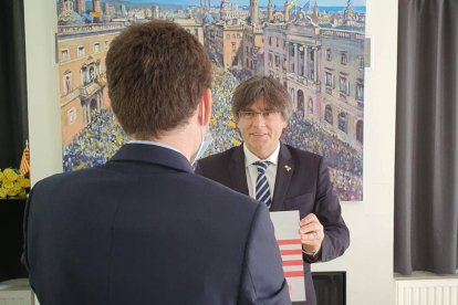 Carles Puigdemont rebent la placa del Consell per la República de mans del noi que la va robar.