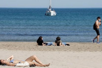 Varías personas tomando el sol en Valencia.