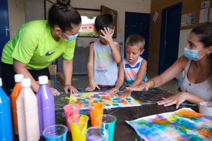 Dos infants de l'Escola Estela amb les seves educadores, aquest estiu.