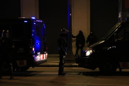 Un home detingut, de cara a la paret, entre diversos agents dels Mossos i furgonetes, a Plaça Catalunya.