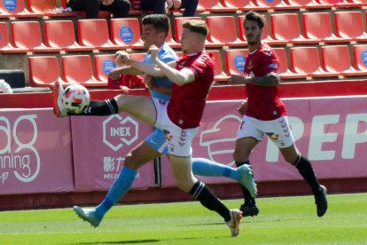 Pol Domingo tomando la pelota de un rival.