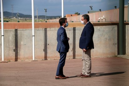 Plano general del presidente de la Generalitat, Pere Aragonès, conversando con el director general de Servicios Penitenciarios.