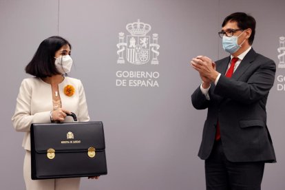 Carolina Darias cogiendo la cartera de ministra de Sanidad acompañada de Salvador Illa.