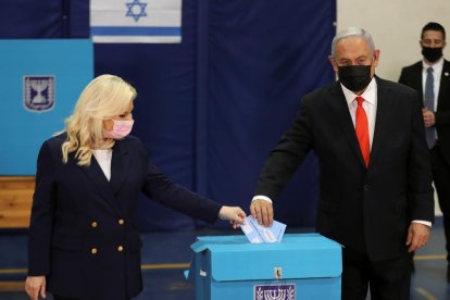 El primer ministro israelí, Benjamin Netanyahu, y su mujer depositan el voto en las elecciones en el país.