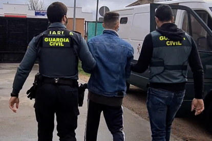 Agentes de la Guardia Civil se llevan a uno de los detenidos.