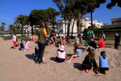 Pla general d'un grup d'escolars plantant plantes al dunar del parc de Voramar d'Altafulla.