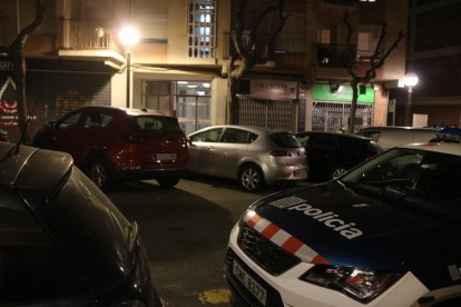 Un cotxe de policia davant del portal del bloc on ha aparegut morta una dona d'edat avançada amb signes de violència.