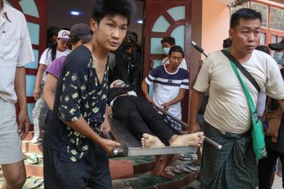 El cuerpo de un joven de 18 años que recibió un disparo en la cabeza es transportado durante los disturbios en Birmania (Myanmar).