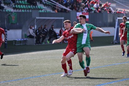 Pol Domingo lluitant amb un jugador del Cornellà durant el partit.