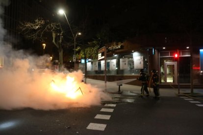 Els Bombers apagant una de les barricades que s'han fet a Barcelona durant els aldarulls.