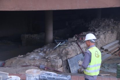 Pla mitjà d'un operari treballant a les restes arqueològiques que han aparegut a la plaça de la façana de la catedral de Tortosa.