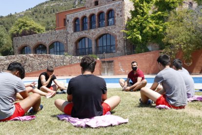 Unos menores haciendo estiramientos a los jardines de un centro terapéutico para adolescentes, del grupo Amalgama7, ubicado en el Alt Camp.