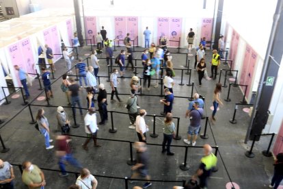 Persones esperant i avançant en una cua per rebre la vacuna de la covid-19 a Fira de Barcelona.