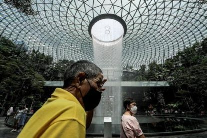 Persoens amb mascaretas a l'aeroport de Changi, a Singapur.