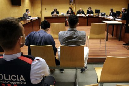 De espaldas y custodiado para|por los Mossos d'Esquadra, el acusado de violar a una chica y retenerla durante horas en Blanes.