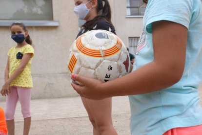 Plano detalle de una pelota a manos de una niña participando en el centro de verano de la Fundació Pere Tarrés en Torredembarra.