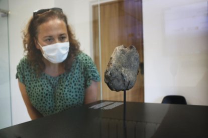 Una vecina de Ulldemolins que observa la plaqueta del Paleolítico Superior encuentro en diciembre en las Cuevas del Hacemos.