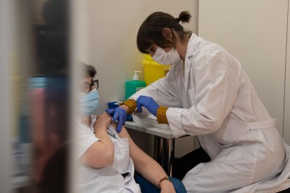 Una professional de l'Hospital Clínic rep la tercera dosi de la vacuna contra la covid-19.