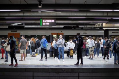 Usuarios de Renfe esperando en los andenes de la estación de Sants en Barcelona.