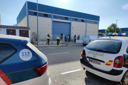 Agentes de los Mossos d'Esquadra y la Policía Nacional entrando en una nave en la calle Flequers del Polígon Industral Alba en Reus.