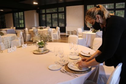 Una camarera parando una mesa en la sala de un restaurante. Imagen de archivo.