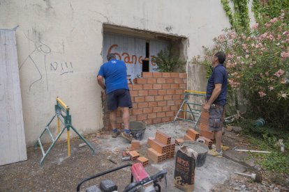 Dos operaris tapien una de les portes d'accés a l'antic sociosanitari Casablanca, que està tancat des de l'any 2005.