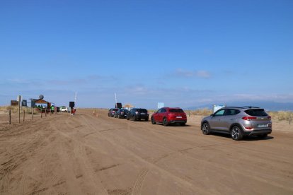 Plano general de los vehículos haciendo cola para acceder a la playa del Trabucador.