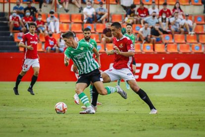 Pablo Fernández luchando una pelota contra un defensor del Betis.