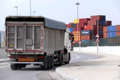 Un camión saliente de terminal de ICL al Puerto de Barcelona con contenedores al fondo.