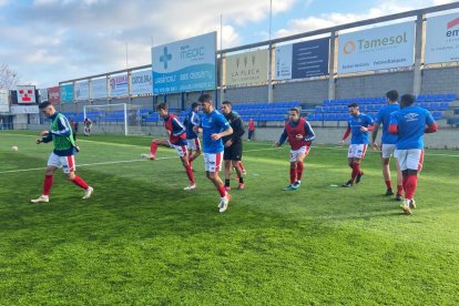 Los futbolistas del Nàstic ejercitándose antes de empezar el duelo en Palamós.