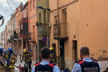 Plano abierto de los cuerpos de seguridad supervisando la vivienda donde se ha declarado el incendio.