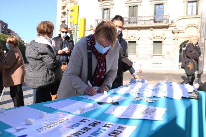 Una dona firmant les peticions fetes pels membres del grup.