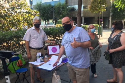 Dos vecinos firmando en la esquina con Higini Anglès.