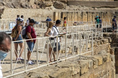 Visitantes paseando por la zona de la arena y disfrutando del acceso gratuito al Anfiteatro.