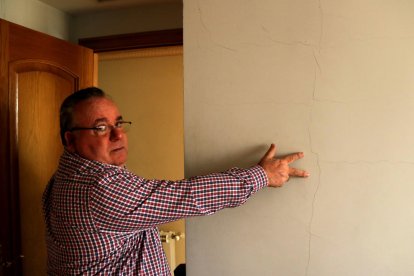 Plano medio de José Miguel Monllaó mostrando una grieta a la pared de una habitación de su casa de Amposta causada por los terremotos del proyecto Castor.