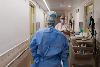 Professionals sanitaris en un passadís de la sala d'hospitalització del Servei de Malalties Infeccioses de l'Hospital Clínic