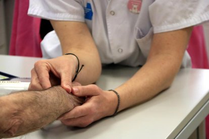 Les mans d'una infermera prenent el pols a un pacient, al CAP Vinyets de Sant Boi de Llobregat