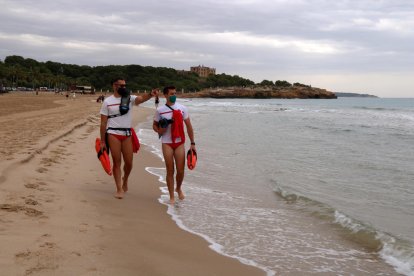 Dos socorristas en la playa de la Arabassada haciendo tareas de vigilancia el primer fin de semana de servicio.