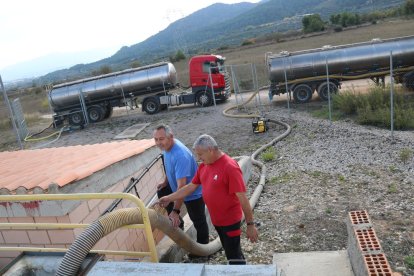 Unos operarios traspasando agua de los camiones cuba al depósito de l'Espluga de Francolí, por la situación de sequía que sufre.