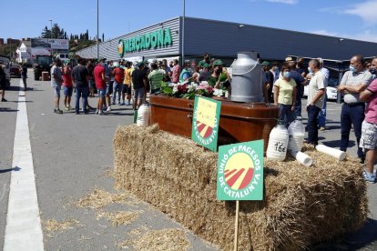 Un primer pla del taüt i garrafes de palla amb la mobilització dels pagesos de fons davant el Mercadona de Vic el 27 de juliol del 2021.