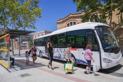 Usuarios del transporte público esperando para subir al autobús en la parada Reus Centro (Paseo)