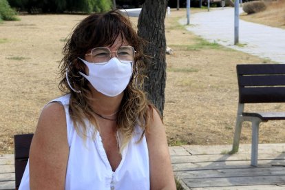 Sílvia Soler, portaveu del Col·lectiu d'afectades i afectats persistents per la covid-19, asseguda en un banc del Passeig Marítim de Castelldefels