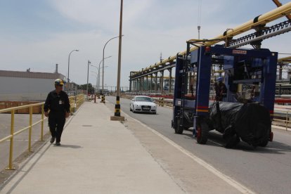 Un trabajador pasa al lado de una carretilla|carretón que transporta una pieza al polígono Norte.