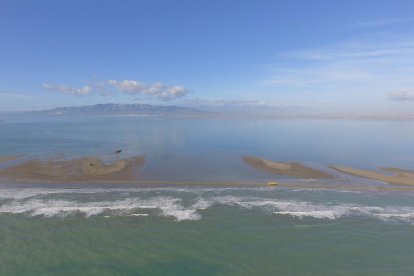 Plano aéreo de uno de los canales abiertos por la Filomena en la barra del Trabucador, cono la bahía de los Alfacs al fondo.