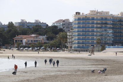 Panoràmica de platja de la Pineda, al terme de Vila-seca, a l'hivern, amb pocs visitants passejant-hi.